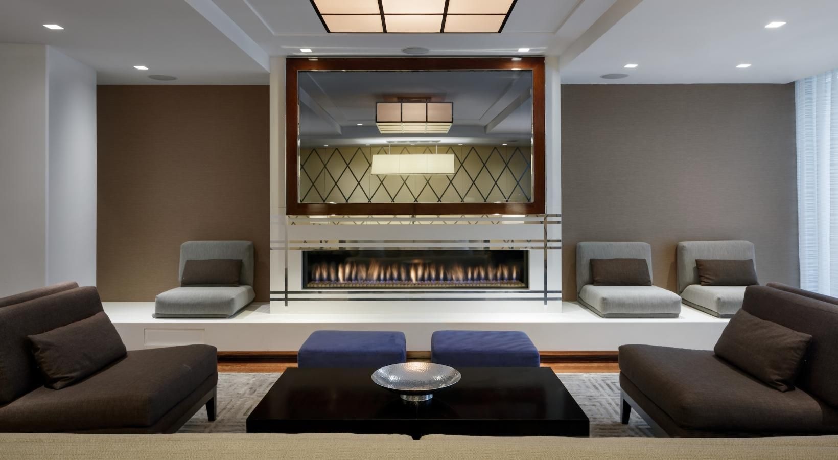 Take advantage of all The Larstrand has to offer a room with a large glass wall and a couch and a round table